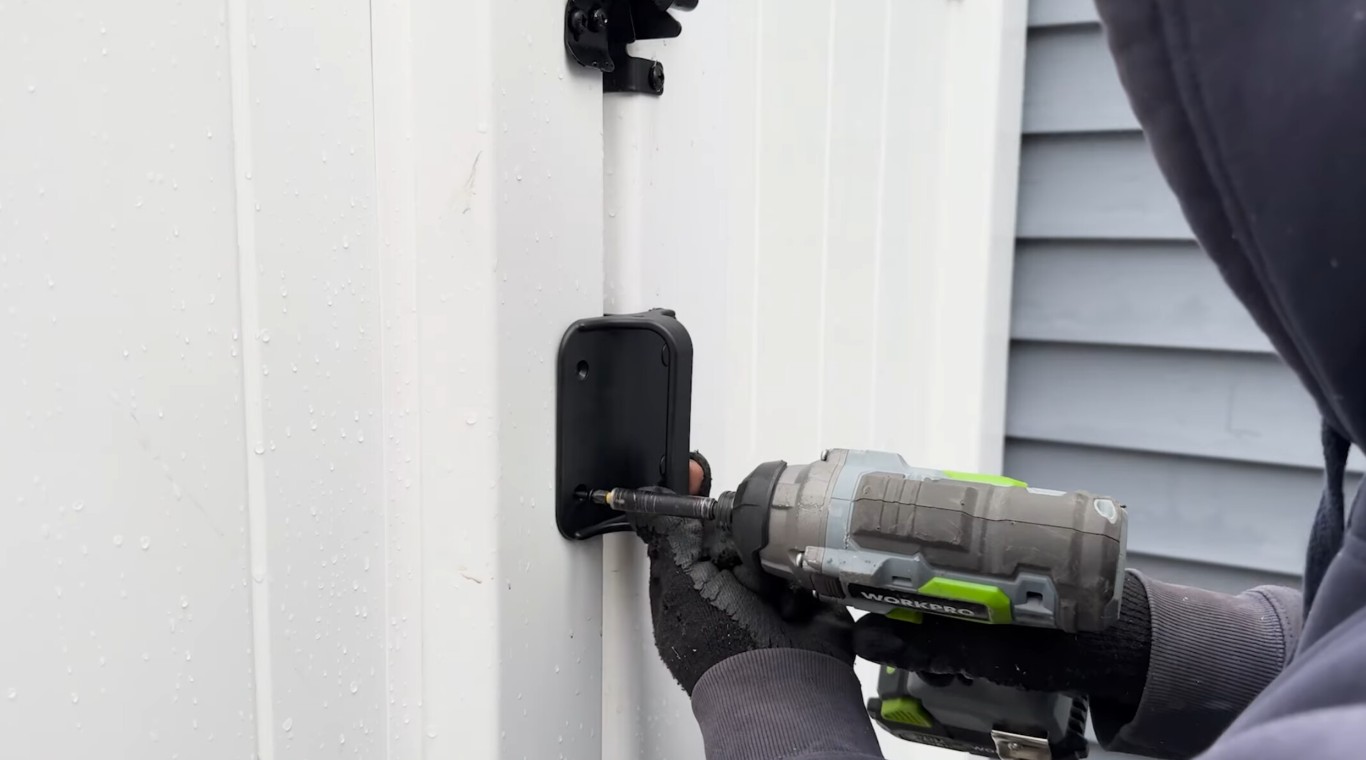 Professional fence installation contractor working on white vinyl fence in Pike Road, AL